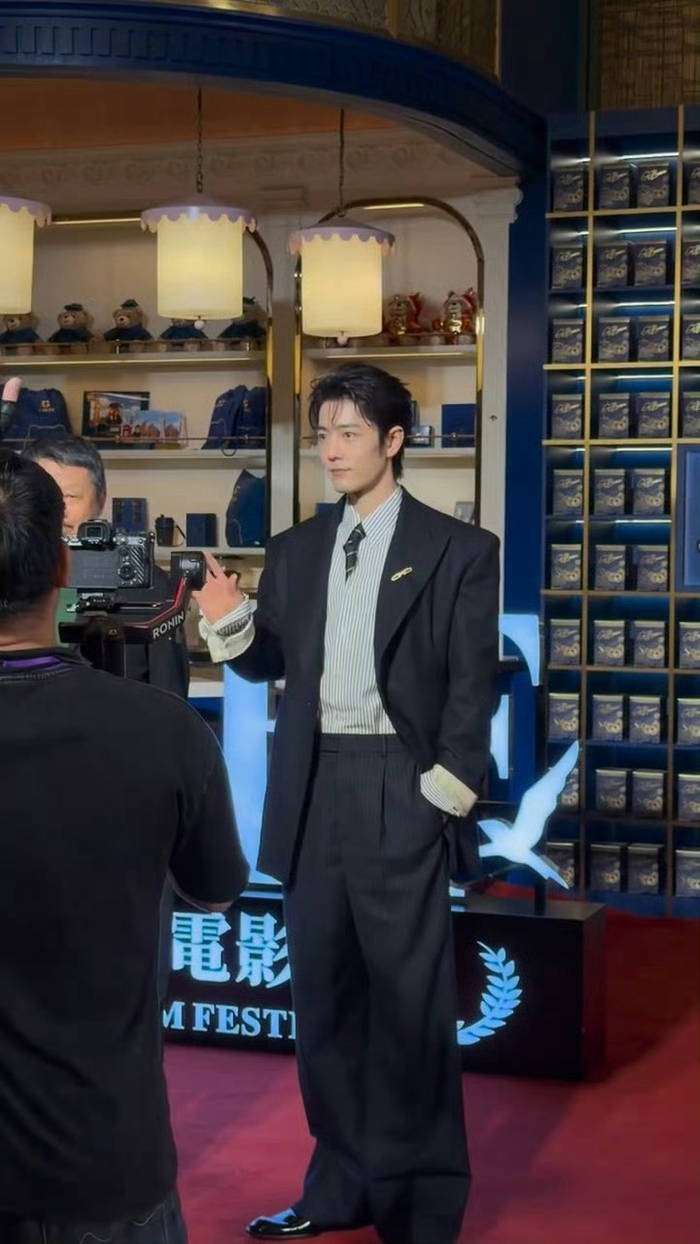 从颁奖季热门选手到红毯气氛担当，肖战用一个轻轻回眸证明：顶流的魅力从不只是流量。当兰晓龙的手还没从耳边放下，当导演孔笙在一旁挠头憨笑，这场融合尖叫、卡顿和欢笑的红毯秀，早已超越了普通的明星亮相——它更像一场属于观众、演员与创作者的集体狂欢。正如网友所说：「别人走红毯带团队，肖战走红毯带交响乐团（指粉丝应援）」。那个让直播卡顿的回眸，也许正是2026年内娱最生动的「人气具象化」现场。